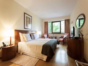 een hotelkamer met een bed en een televisie bij Stay in the heart of Lisbon- Altis Suites Hotel 4* in Lissabon