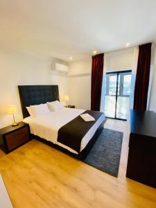 una camera da letto con un letto e una grande finestra di Lovely apartment for family and group of friends a Póvoa de Santa Iria