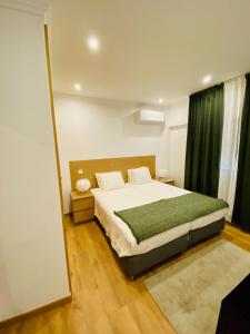 una camera da letto con un letto grande e uno specchio di Lovely apartment for family and group of friends a Póvoa de Santa Iria