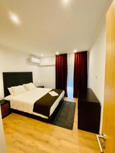 - une chambre avec un lit et des rideaux rouges dans l'établissement Lovely apartment for family and group of friends, à Póvoa de Santa Iria