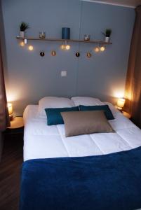 a bedroom with a large white bed with lights on it at Mobilhome climatisé-2ch-terrasse fermée-camping Les Charmettes in Les Mathes