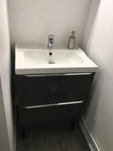 ein Bad mit einem weißen Waschbecken im Zimmer in der Unterkunft Studio 15 in Honfleur