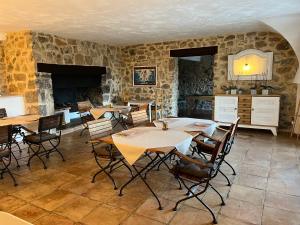 a dining room with tables and chairs and a fireplace at Fleur de Lys in Fayence