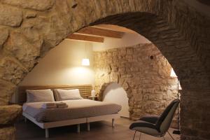- une chambre avec un lit dans un mur en pierre dans l'établissement Albertario, à Acquaviva delle Fonti