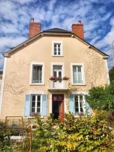 een groot wit huis met een balkon en 2 ramen bij La Joséphine in Cosne Cours sur Loire