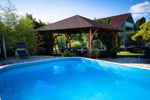 a swimming pool in a yard with a gazebo at Marietta Apartman in Hévíz