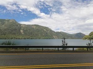 a road with a view of a lake and mountains at Casa Bilbao Villarrica in Villarrica
