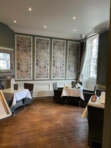 a dining room with two tables and chairs and windows at The Spread Eagle Hotel in Thame