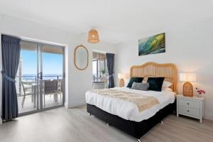 um quarto com uma cama grande e uma varanda em Maroochy Sands Holiday Apartments em Maroochydore