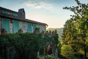an old house with potted plants on a wall at Celle di lecchi nel Chianti in San Sano