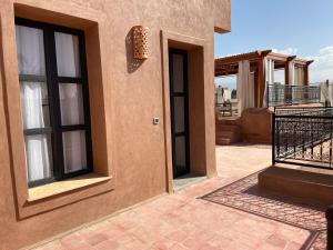 Casa con balcón y puerta en el patio en Villa Scil de luxe 3 Suites Piscine chauffée Hamam Jacuzzi extérieur avec vue sur l'Atlas 2 Parkings Privé en Marrakech