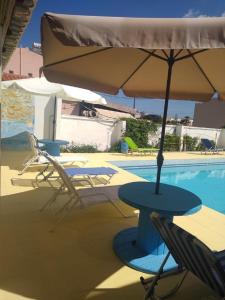 a table and chairs with an umbrella next to a pool at Villas Irene 6 Family Apartments in Gournes