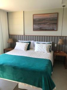 1 dormitorio con 1 cama grande con sábanas azules y blancas en Apartamento 3/4 maravilhoso no Village das Acácias, en Praia do Forte