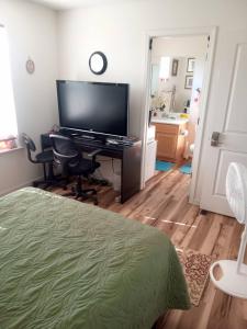 a bedroom with a television and a desk with a chair at Room in Campbell with Own Bthrm in Campbell +15 photos
