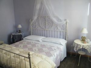 sypialnia z łóżkiem z baldachimem i dwoma stołami w obiekcie Appartamento Vacanze I Provenzali w mieście Bordighera