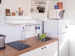 Kyrkesundにある4 person holiday home in KYRKESUND-By Traumのシンクと白い冷蔵庫のあるキッチン