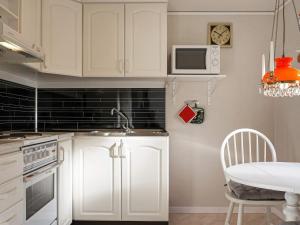 比克瑟爾克魯克的住宿－Holiday home Byxelkrok IV，厨房配有白色橱柜、桌子和时钟