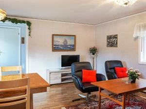 - un salon avec des chaises, une table et une télévision dans l'établissement Holiday home Byxelkrok IV, à Byxelkrok