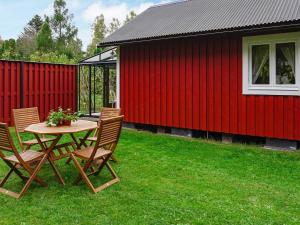 a table and chairs in a yard next to a red building at 4 person holiday home in Byxelkrok-By Traum in Byxelkrok +7 photos