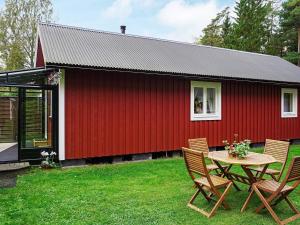 una casa roja con una mesa y sillas frente a ella en Holiday home Byxelkrok IV, en Byxelkrok