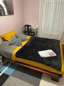 een bed met een zwarte en gele deken erop bij Chambres d'hôte in Sennecey-le-Grand