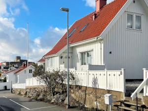 a white house with a red roof and a street light at Holiday home MARSTRAND III in Marstrand
