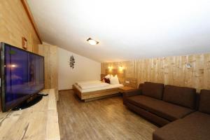 a living room with a couch and a television at Semi-detached house, Zell am Ziller in Zell am Ziller
