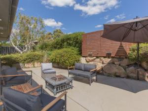 a patio with two chairs and an umbrella at Jackson Hole 3 in Jindabyne