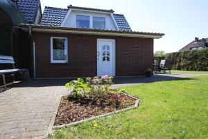 a brick house with a white door and a yard at Holiday home, Plau am See in Plau am See