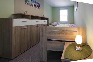a bedroom with a bunk bed with a desk and a drawer at Holiday home, Plau am See in Plau am See