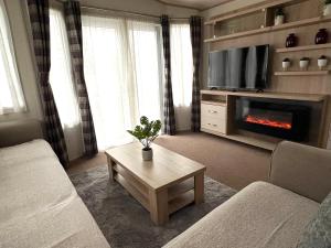 a living room with a couch and a fireplace at Forest & Beach Escape in Sway