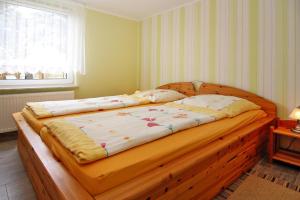 a large wooden bed in a room with a window at Cottage, Karl Hagen in Ostseebad Karlshagen