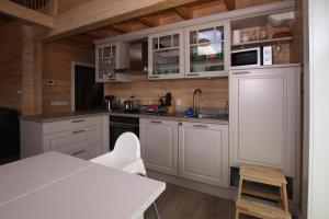 een keuken met witte kasten en een witte tafel bij Holiday house at the Schaalsee, Zarrentin in Zarrentin