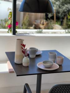 una mesa con platos y tazas y una lámpara en Privat Atelier en Setúbal