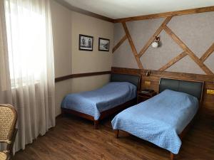 a room with two beds and a window at Nachalnik Kamchatki Hotel in Petropavlovsk-Kamchatskiy