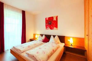 a bedroom with a bed with two lamps and a window at Apartment in Brixen with Pool & Dolomites Views in Naz-Sciaves