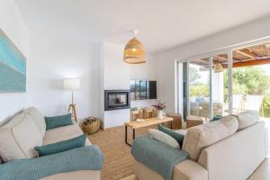 a living room with two couches and a tv at Villa Himala by 3VILLAS in Sant Lluis