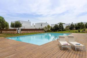 two chairs sitting next to a swimming pool at Villa Himala by 3VILLAS in Sant Lluis