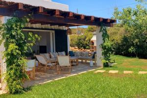 a patio with a table and chairs under a pergola at Villa Himala by 3VILLAS in Sant Lluis +26 photos