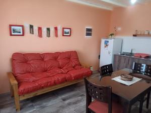a living room with a red couch and a table at Luz de las Sierras in Arroyo de Los Patos