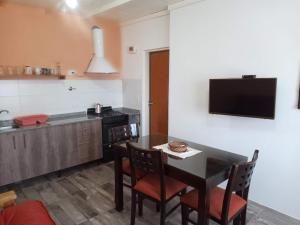 a kitchen with a table and chairs and a television at Luz de las Sierras in Arroyo de Los Patos
