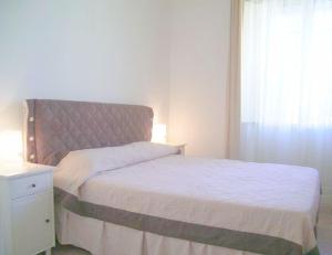 una camera con letto con testiera e finestra di Cathy Apartment a Roma