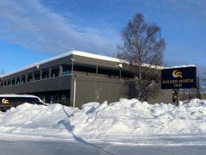 a building with a pile of snow in front of it at Golden North Inn in Fairbanks