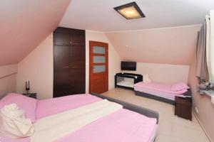 a bedroom with two beds with pink sheets at Comfortable holiday homes Jaroslawiec in Jarosławiec