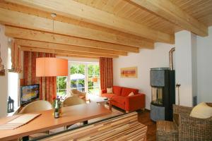 a living room with a red couch and a fireplace at Holiday resort, Greetsiel in Greetsiel