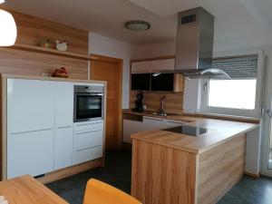 a kitchen with white cabinets and a wooden counter top at Holiday home Hart im Zillertal in Hart im Zillertal