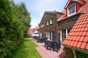 a patio with tables and chairs on a house at Holiday resort, Greetsiel in Greetsiel