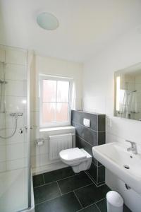 a bathroom with a toilet and a sink and a shower at Ferienhäuser in Greetsiel in Greetsiel +20 photos