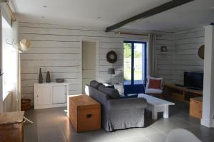 ein Wohnzimmer mit einem Sofa und einem TV in der Unterkunft Holiday Home Locquirec - BRE05104e-F in Locquirec
