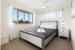 a bedroom with a large bed and a window at Hungerford Beach Apartment by Kingscliff Accommodation in Kingscliff